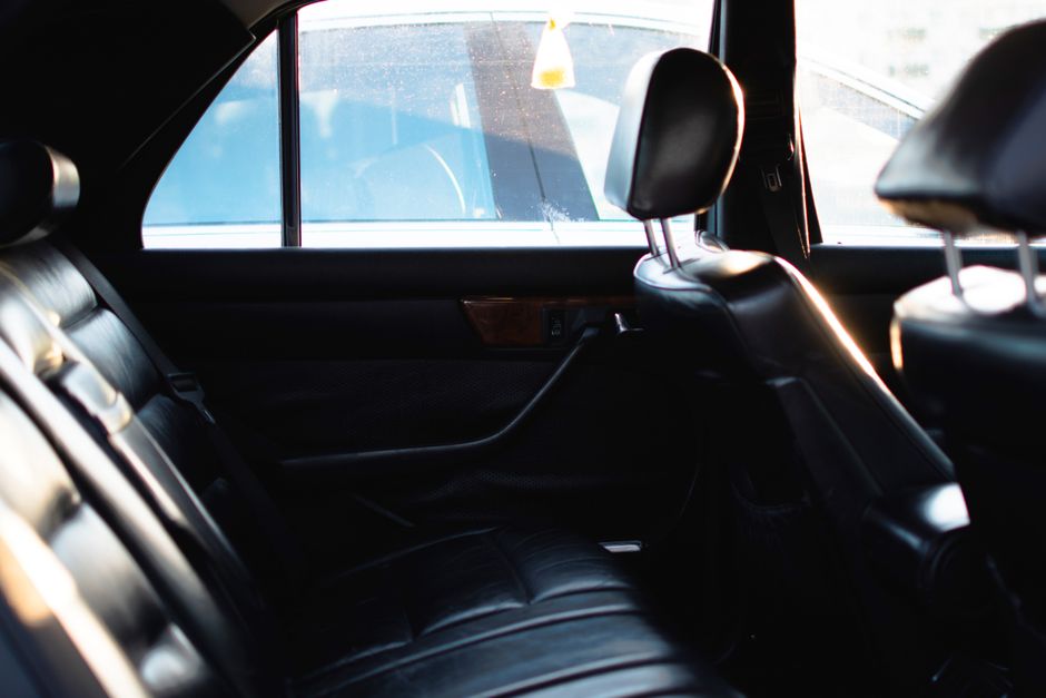 Luxurious car interior with leather seats and window light, showcasing elegance and comfort.
