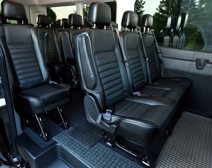 Luxurious black leather seating inside a spacious minivan with ample legroom.